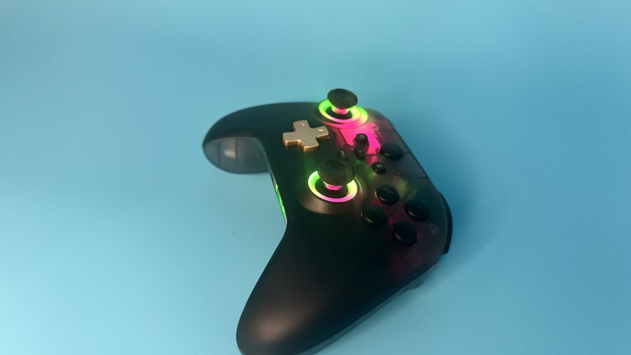 EasySMX D05 black gaming controller from the side (with rainbow RGB) on a blue background