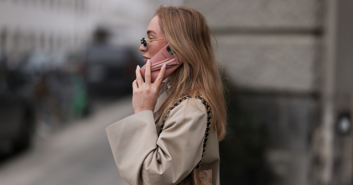 Hairbrush: Sonia Lyson seen wearing Linda Farrow black rectangular sunglasses with dark lenses, adding a modern and edgy touch, Sézane beige oversized trench coat with large statement buttons and a relaxed fit, Louis Vuitton brown logo monogram pattern bucket bag with gold chain straps adds a sophisticated contrast and Rhode pink phone case / lip case with a Rhode pink peptide lip gloss, on March 24, 2025 in Berlin, Germany.