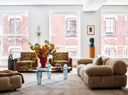 Open plan living room with brown sofas and animal print chairs