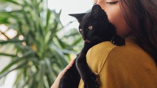 Woman holding a black cat