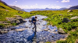 Backpacker crossing high country stream in Colorado