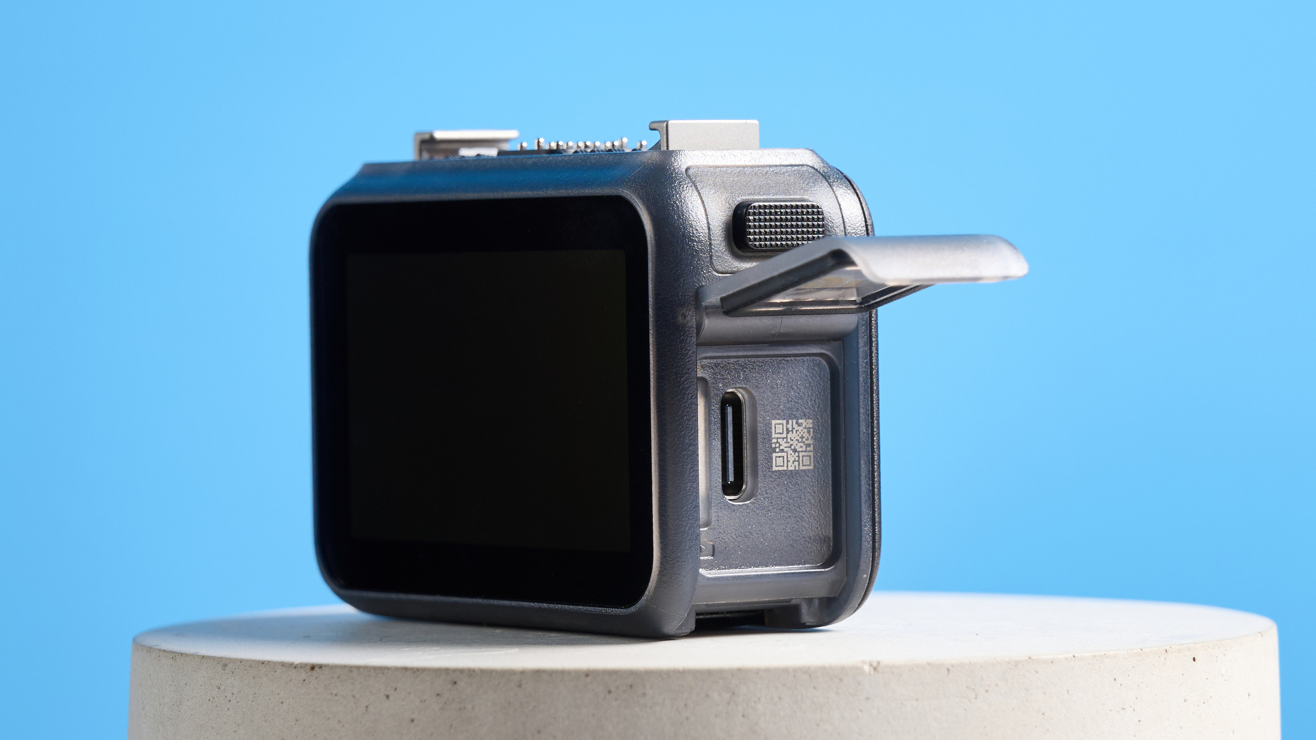 DJI Osmo Nano with its side hatch open against a blue background