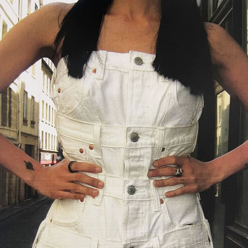 A woman wearing a white denim dress