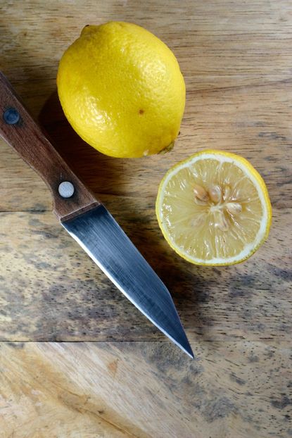 Knife Next To Whole And Cut In Half Lemon