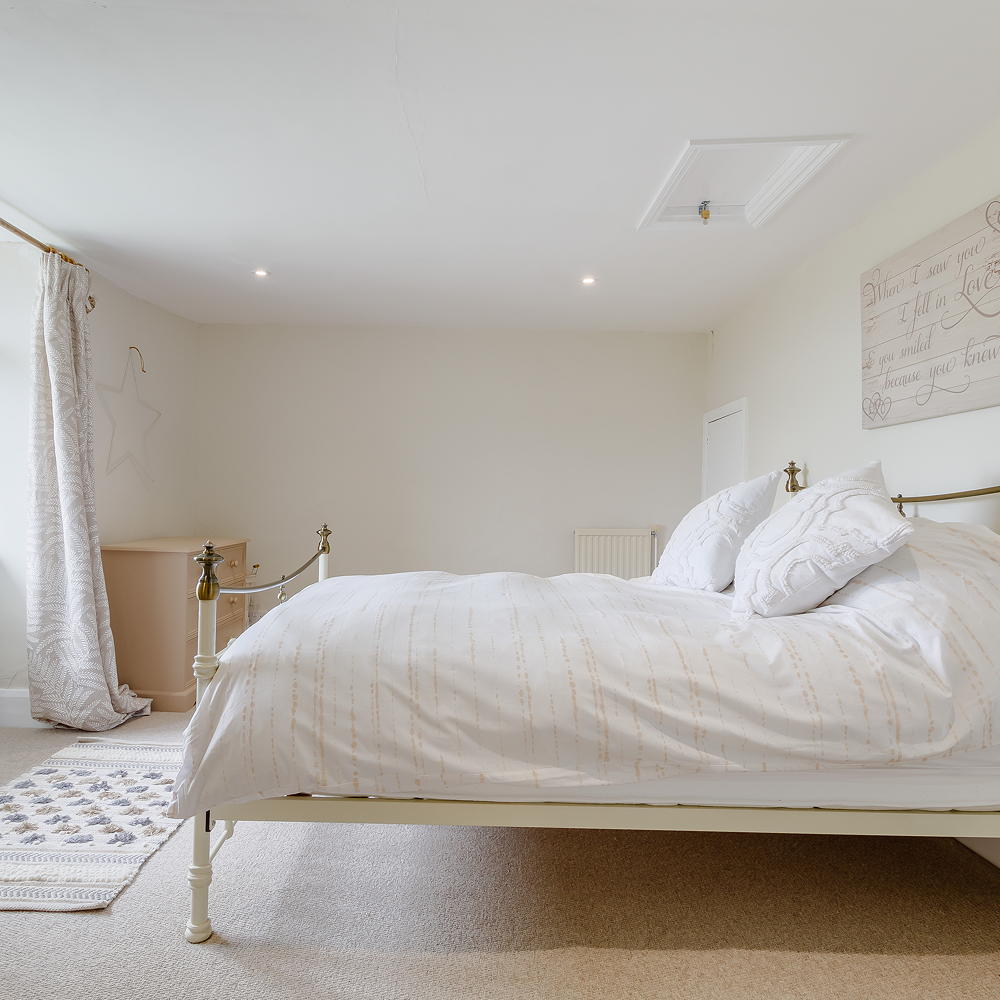 bedroom with white walls and bed with pillows