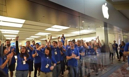 Apple employees cheer early-bird customers at the October launch of the iPhone 4S: The latest iteration of the iPhone led the way for Apple's triumphant earnings last quarter.