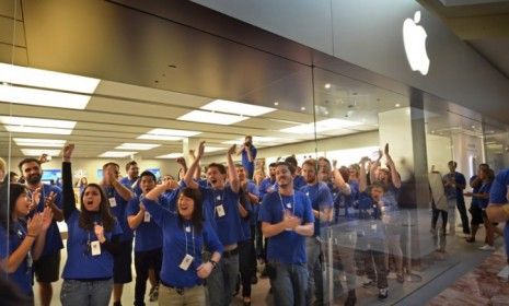 Apple employees cheer early-bird customers at the October launch of the iPhone 4S: The latest iteration of the iPhone led the way for Apple&amp;#039;s triumphant earnings last quarter.