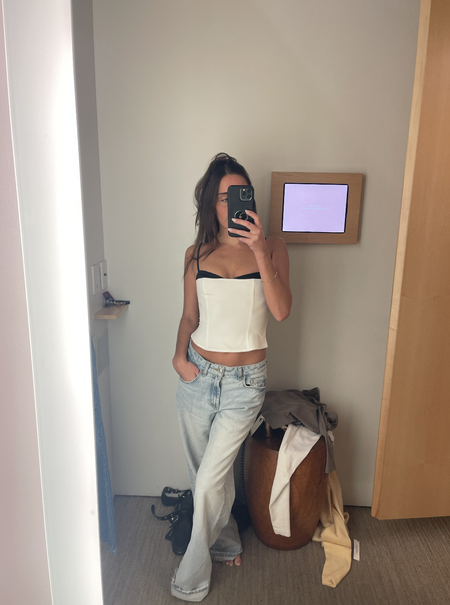 woman taking mirror selfie in reformation fitting room