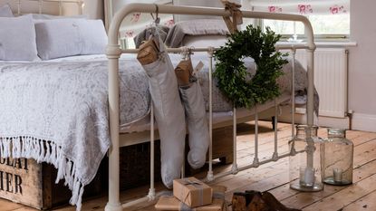 A white metal frame bed with stockings hanging from it