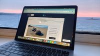 Laptop next to window overlooking the sea, featuring website being edited in GoDaddy interface