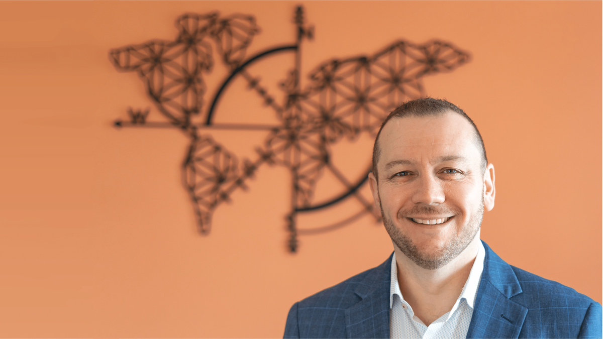 Ryan Poggi headshot against an orange background