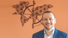 Ryan Poggi headshot against an orange background