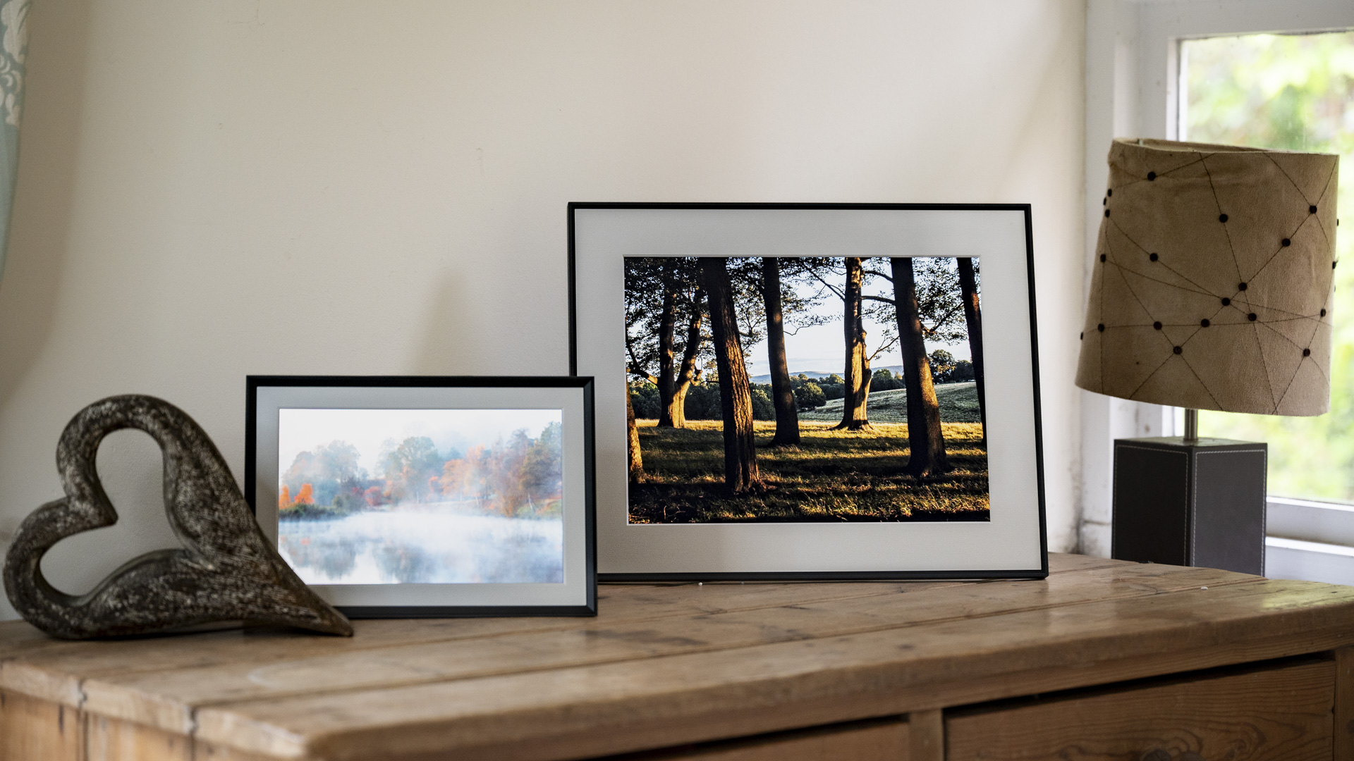 Aura Walden digital photo frame on a wooden sideboard alongside the smaller Aura Carver Mat