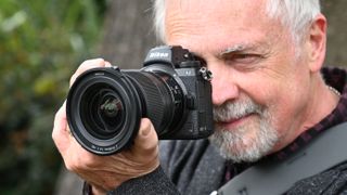 Nikon Z6 II camera and large lens held up to a mans face