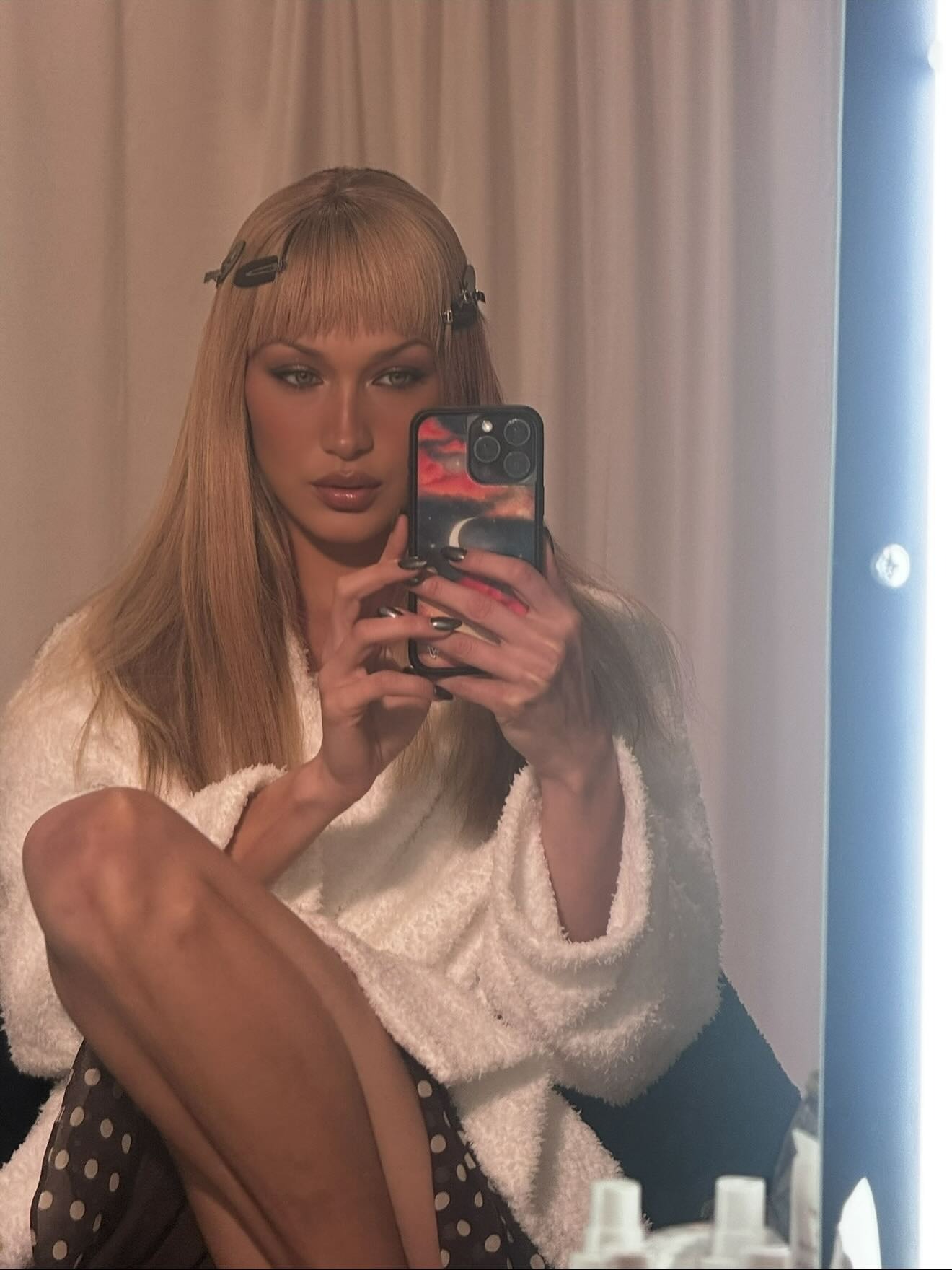 Bella Hadid getting ready with a block fringe hairstyle and hair clips in