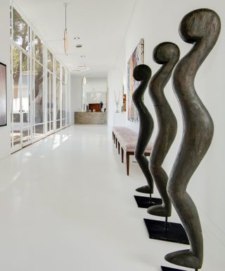 Hallway in Frank Sinatra's home with sculptures and large glass window