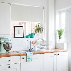 White kitchen with white roller blinds