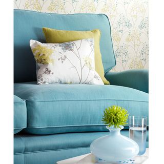 blue sofa set with floral printed cushions and wall