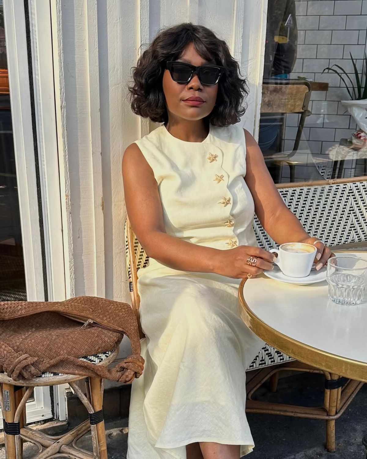 @frannfyne wears a white co-ord and her hair in a curly Monaco Bob