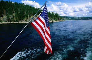 The American flag flying from the back of a boat on Lake Coeur d'Alene in Idaho on a summer day