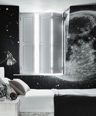 A teenage boys bedroom idea with space wallpaper and white shutters