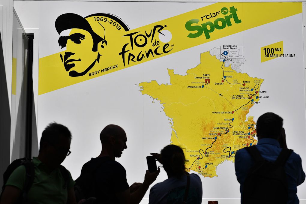 Fans take photos of a van decorated with the route of the Tour de France 2019