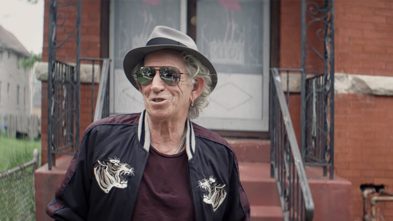 Keith Richards smiling wearing mirrored sunglasses