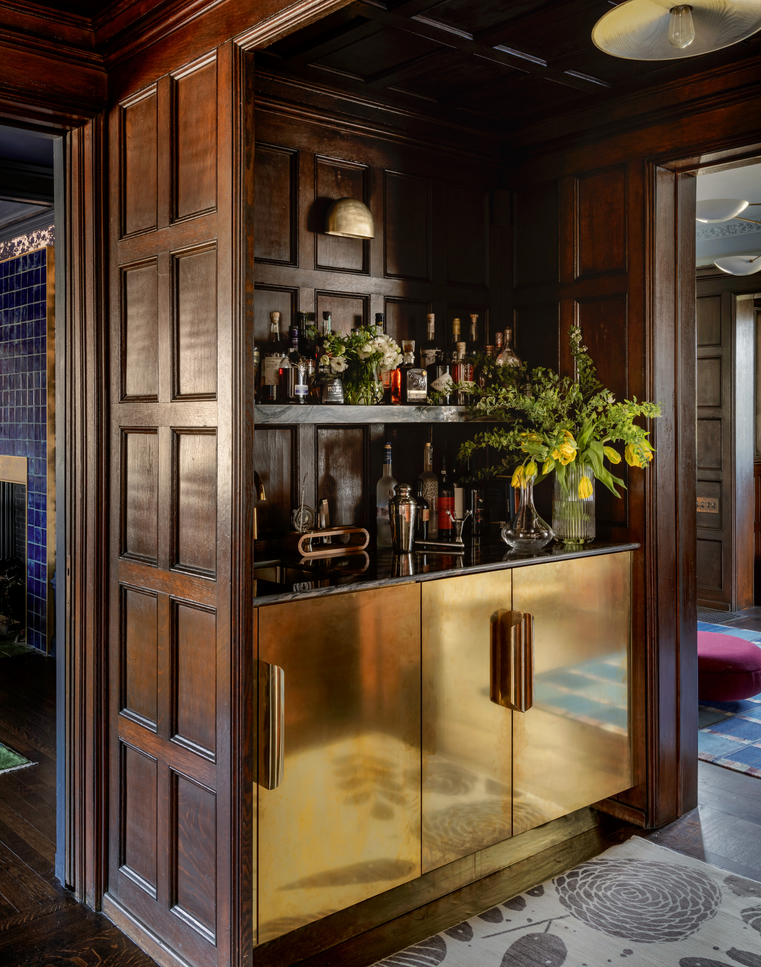 Home bar with wood panelling and gold finish on cupboard