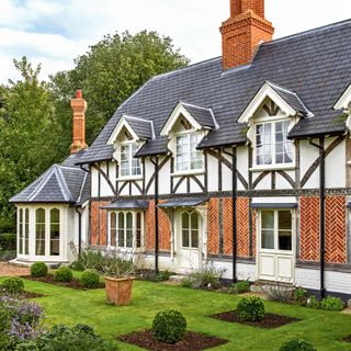 victorian mock tudor home with slate tile roof and brick chimneys