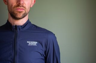 A man wearing a blue Pas Normal waterproof 
