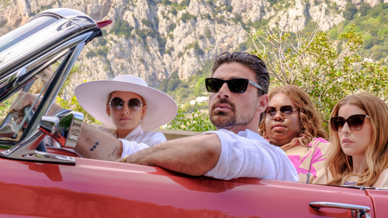 Blake Lively, Michele Morrone, Alex Newell and Anna Kendrick sit wearing sunglasses in a red convertible in Another Simple Favor.