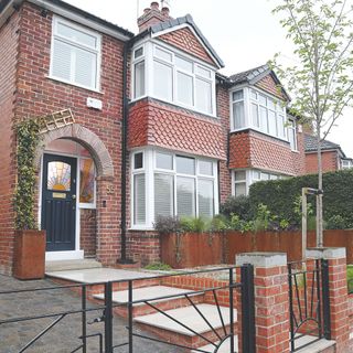 Exterior shot of a house from outside the gated driveway