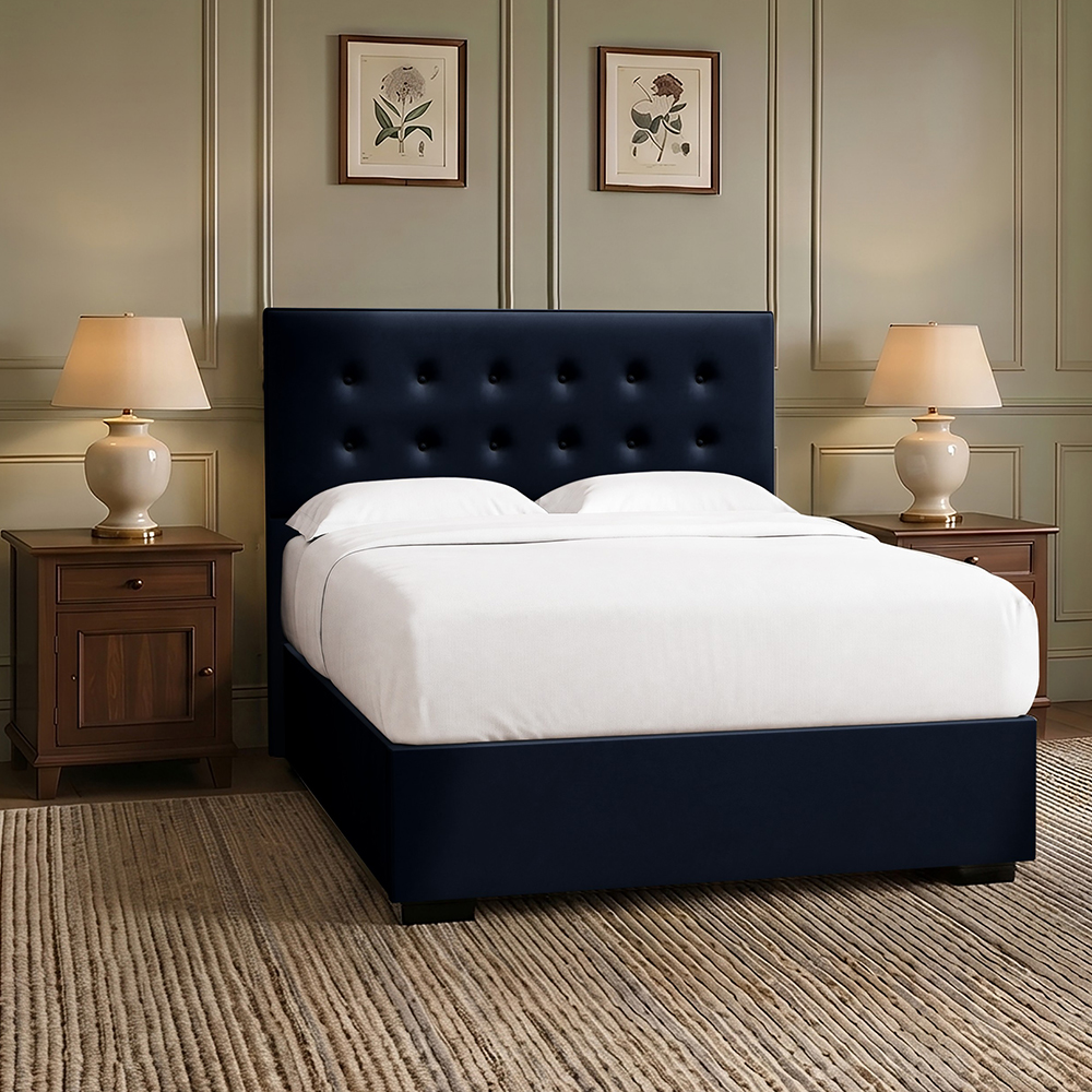 Navy blue button-backed upholstered bed in a sage green bedroom