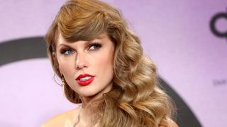 Taylor swift wearing gold shimmering eyeshadow with matte red lipstick