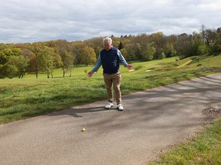 Jezz Elwood with his arms out in confusion when finding his golf ball on the path