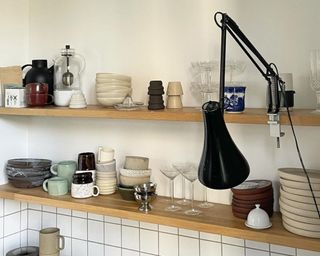 Small kitchen with floating shelves and dishes on display
