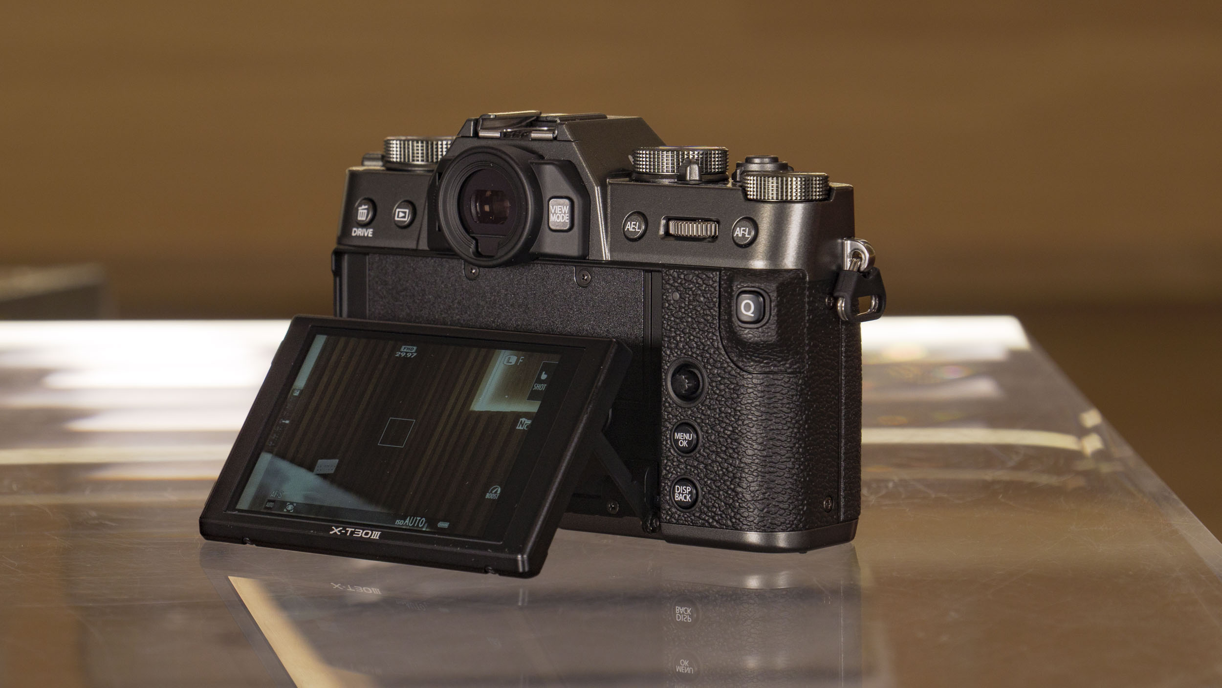 Tilt screen of the Fujifilm X-T30 III camera pulled out, on a glass table