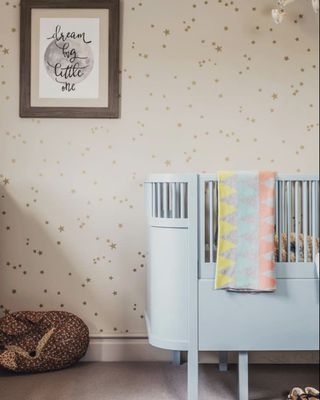 A nursery with a subtle star print wallpaper