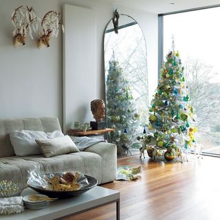 living room with white wall grey sofa and christmas tree