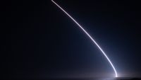 a streak of light arcs into the night sky