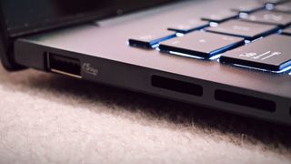 A blue ASUS Zenbook 14 OLED (UX3405) on a carpeted floor