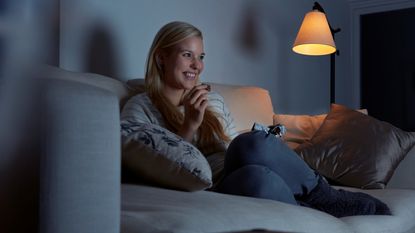 Woman watching TV while eating chocolate
