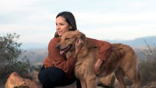 Woman and dog outside cuddling