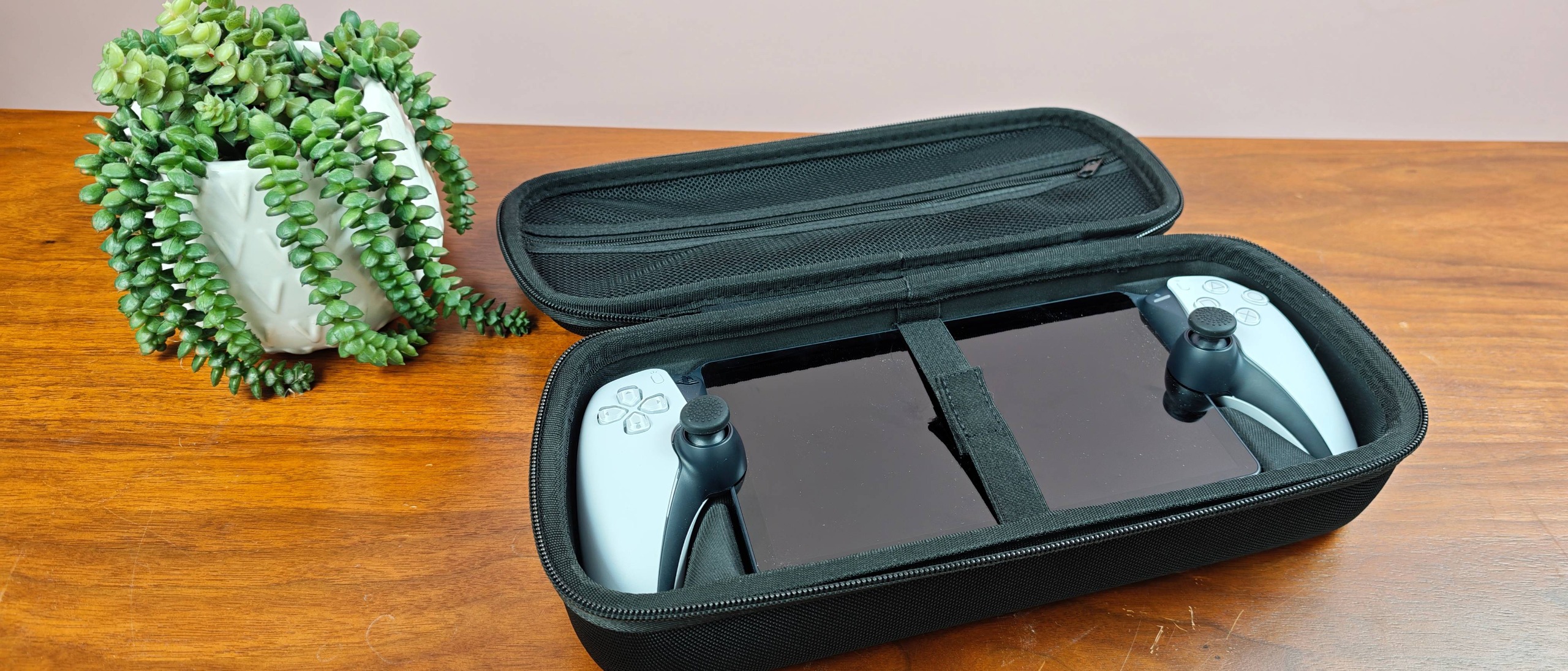 Venom PlayStation Portal Carry Case with PS Portal and plant on table