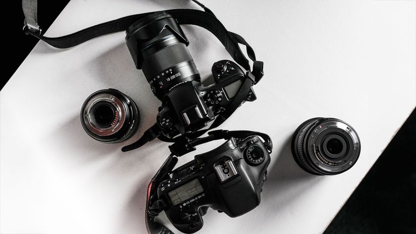 A top-down view of two DSLR cameras with different lenses on a white surface, showcasing their detailed designs and features