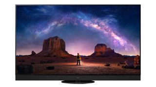 Panasonic Z95A OLED TV on a white background. On the screen is a person in a desert looking up at a star constellation.