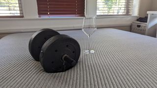 Testing the motion isolation of the Casper Original mattress using an empty wine glass and a weight