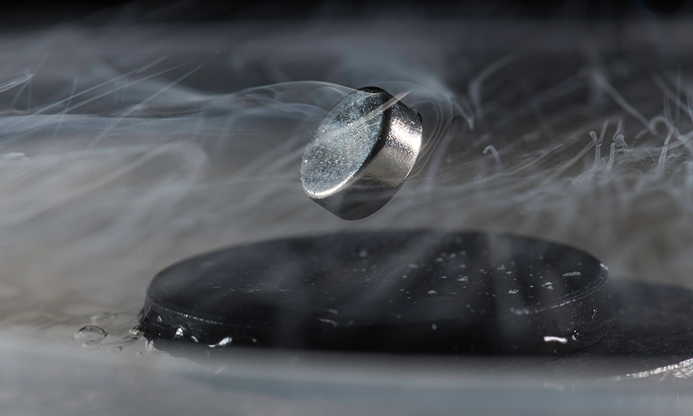 Currently, extreme cold is required to achieve superconductivity, as shown in this photo of a magnet floating above a superconductor cooled with liquid nitrogen.