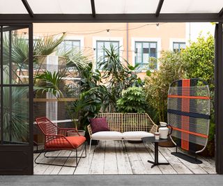 decorative screens and large plants used to add privacy to a balcony