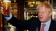 Boris Johnson holds up a pint of lager 